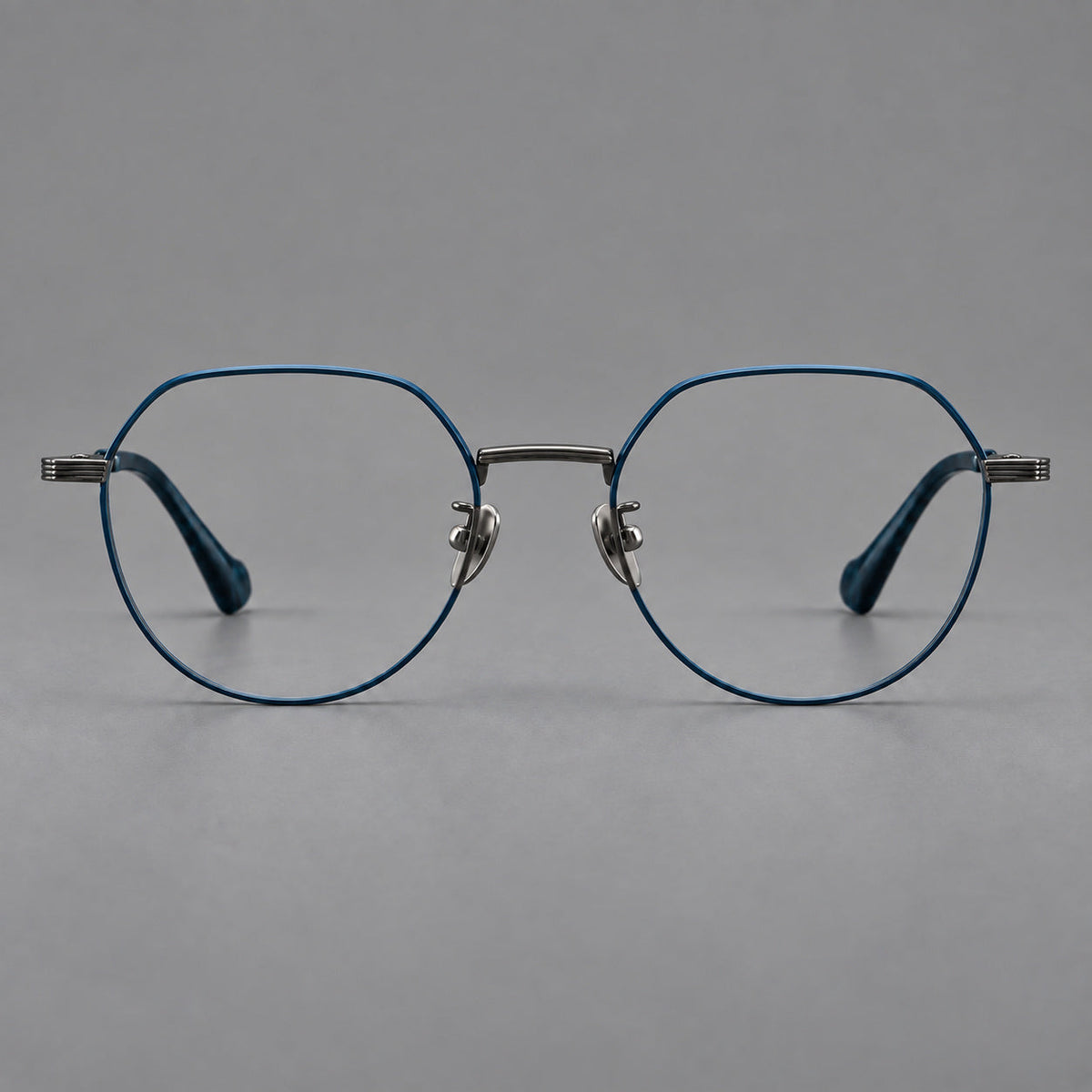 Geometric titanium glasses with soft polygonal rims and fine shoulder detailing in Blue and Gunmetal, front view