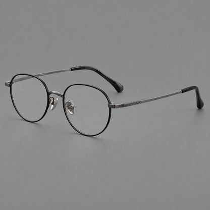 Compact round titanium glasses with an arched bridge and textured temple accents in Black and Gunmetal, three quarter view front view