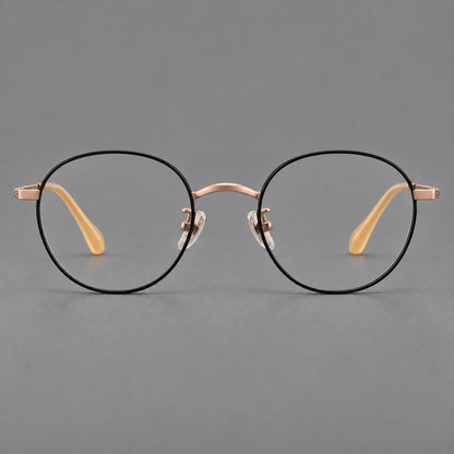 Compact round titanium glasses with an arched bridge and textured temple accents in Black and Rose Gold, front view temple detail