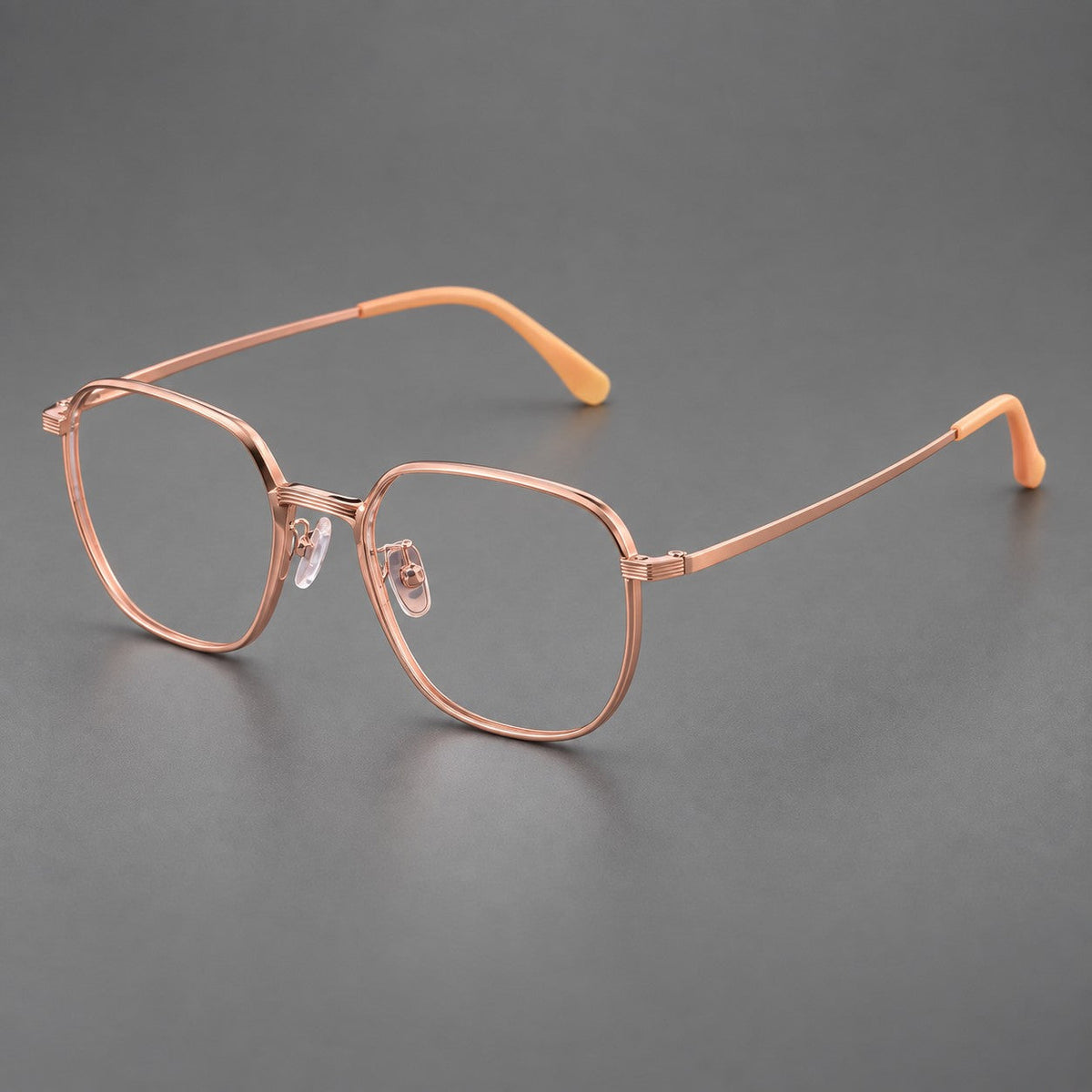Geometric titanium glasses with flattened corners and a finely ridged bridge in Rose Gold, three quarter view