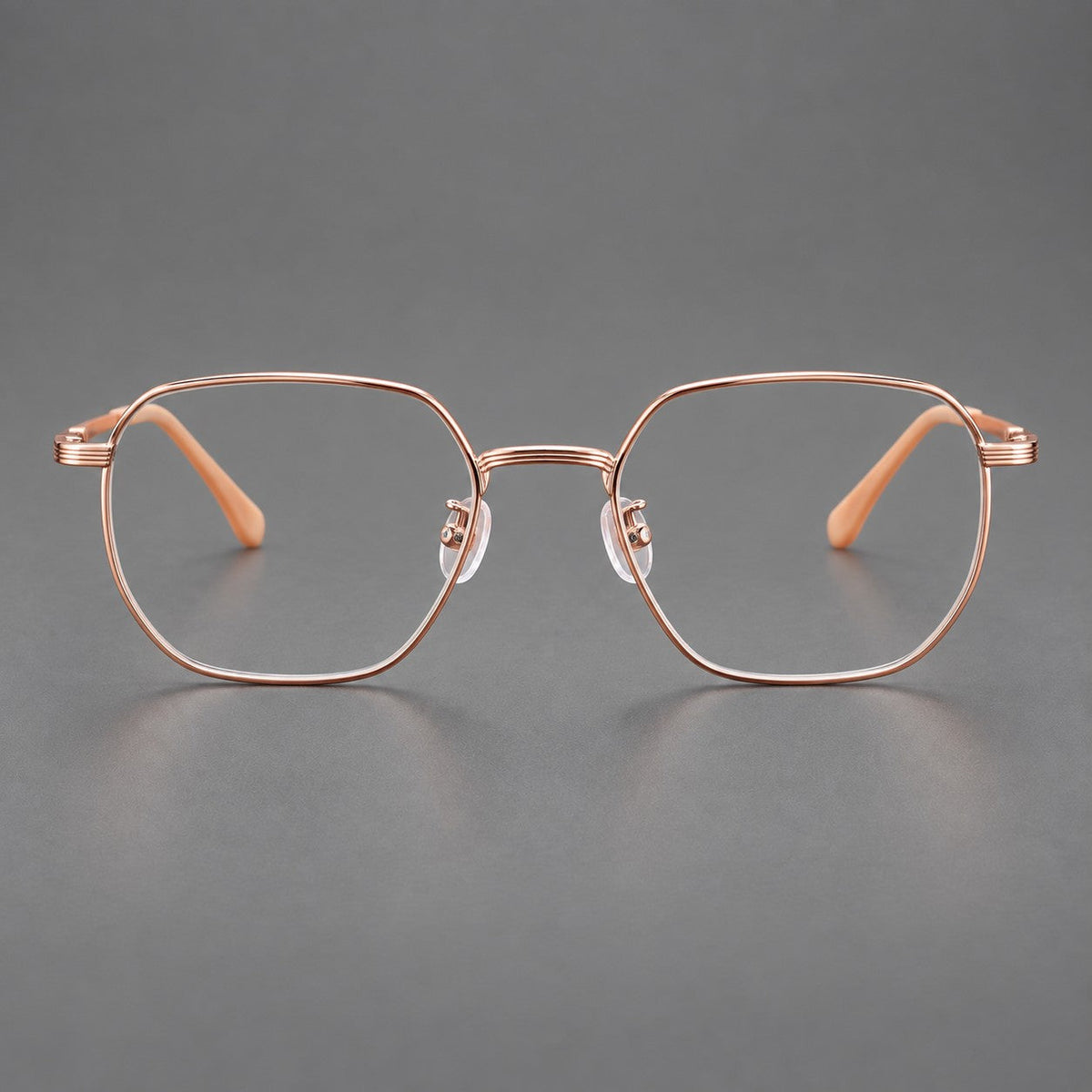 Geometric titanium glasses with flattened corners and a finely ridged bridge in Rose Gold, front view