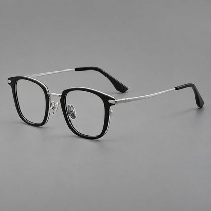Bold square titanium glasses with a separate bridge and long metal corner accents in Black and Silver, three quarter view lens detail