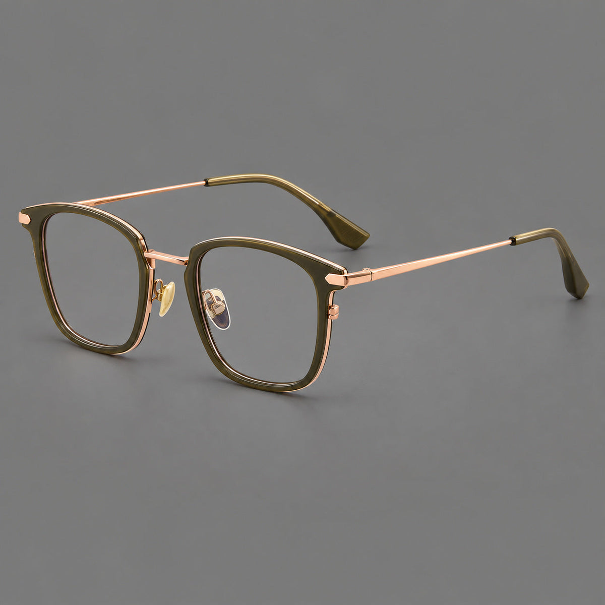 Bold square titanium glasses with a separate bridge and long metal corner accents in Olive Green and Rose Gold, three quarter view