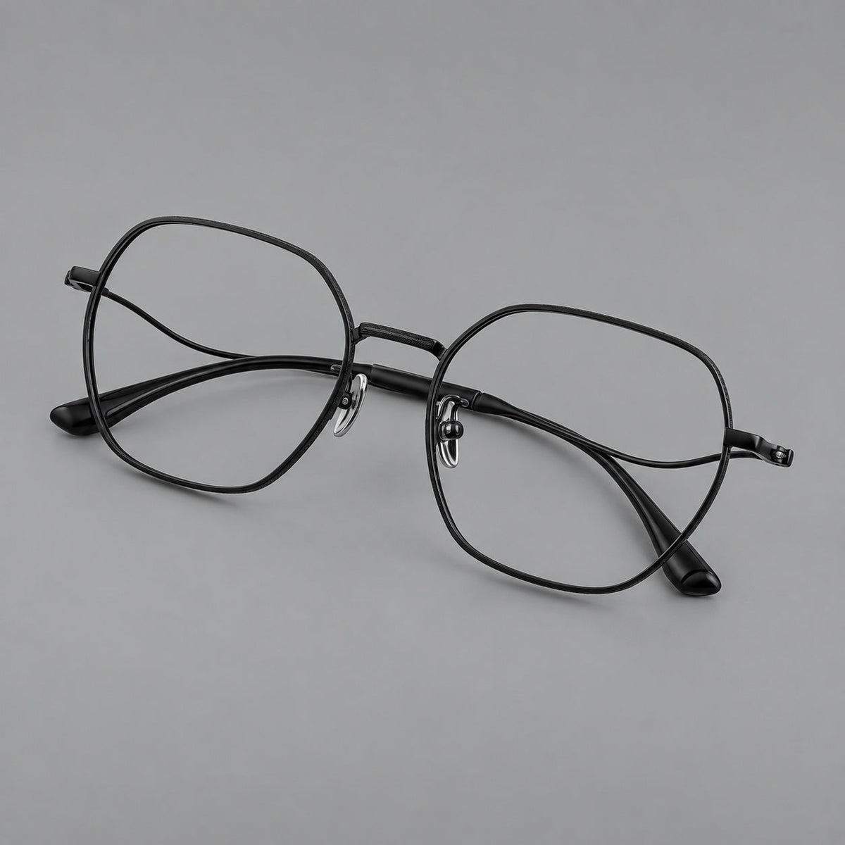 Geometric titanium glasses with engraved rim edges and curved temple joins in Black, three quarter view