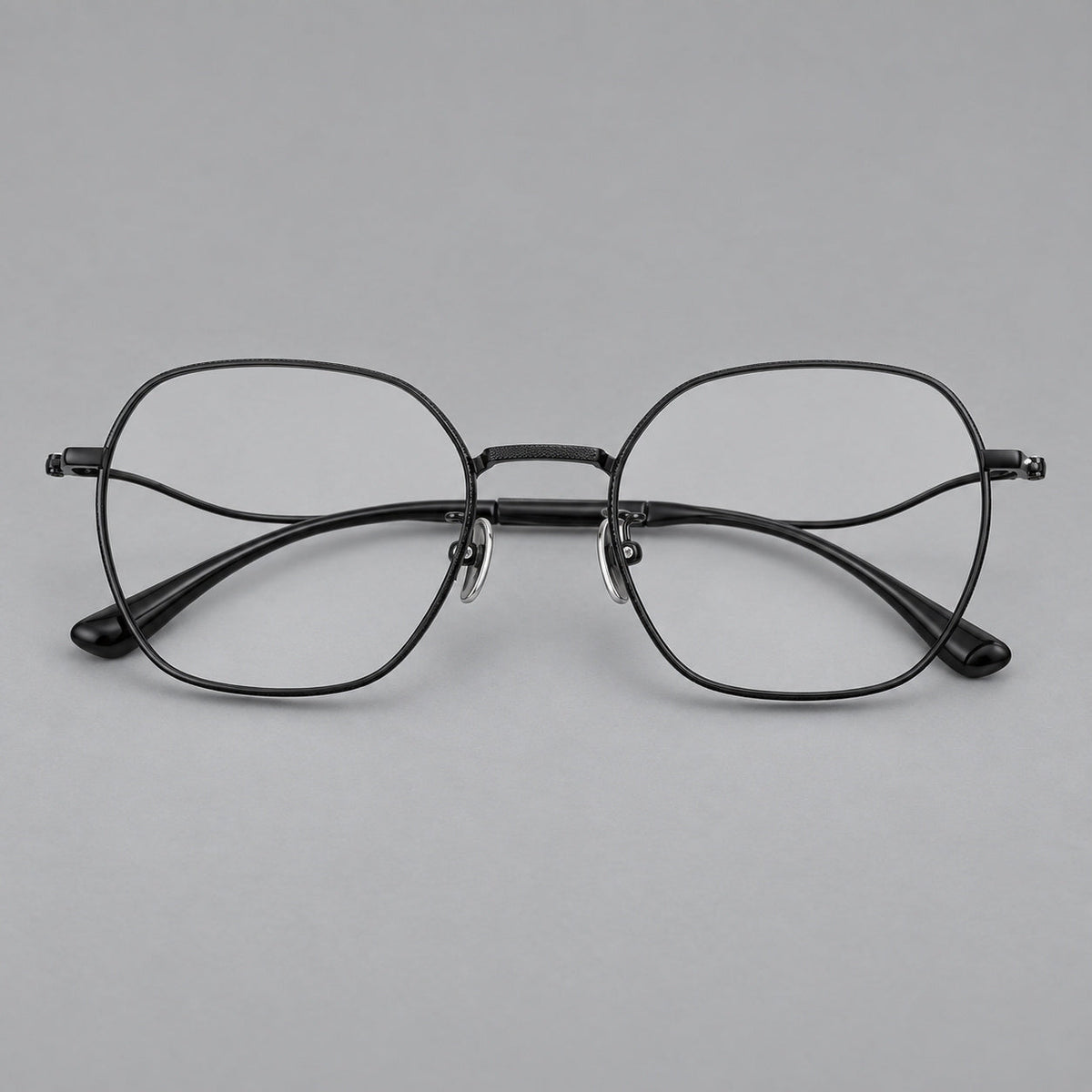 Geometric titanium glasses with engraved rim edges and curved temple joins in Black, front view