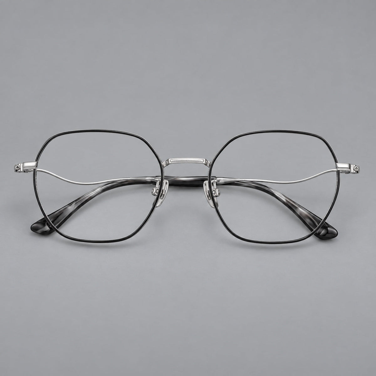 Geometric titanium glasses with engraved rim edges and curved temple joins in Black and Silver, front view