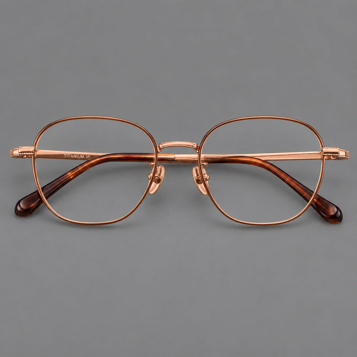 Retro panto titanium glasses with stepped corners and finely engraved temples in Brown and Rose Gold, front view