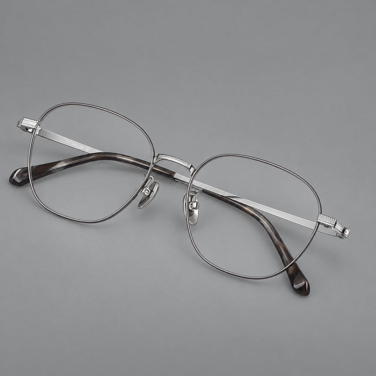 Retro panto titanium glasses with stepped corners and finely engraved temples in Gray and Silver, three quarter view