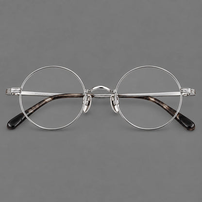 Compact circular titanium glasses with a curved bridge and wavy engraved temples in Silver, front view temple detail