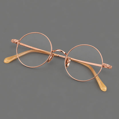 Compact circular titanium glasses with a curved bridge and wavy engraved temples in Rose Gold, three quarter view additional product view