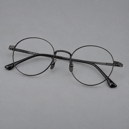 Classic circular titanium glasses with a raised bridge and lined temple accents in Black, three quarter view