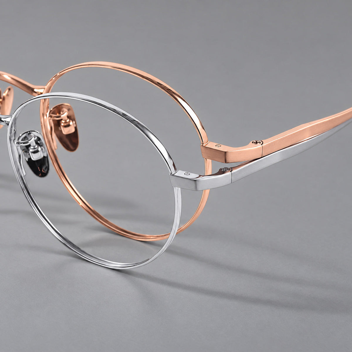 Classic circular titanium glasses with a raised bridge and lined temple accents, frame details
