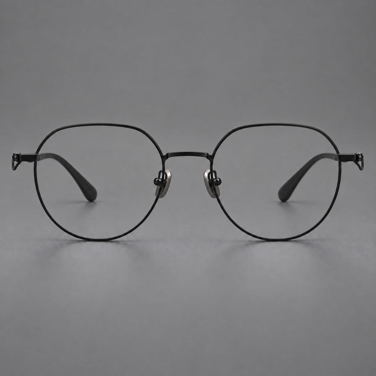 Rounded titanium glasses with a short bridge and distinctive wavy metal temples in Matte Black, front view