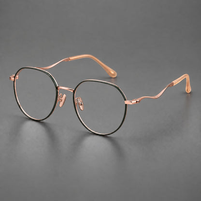 Rounded titanium glasses with a short bridge and distinctive wavy metal temples in Dark Green and Rose Gold, three quarter view lens detail
