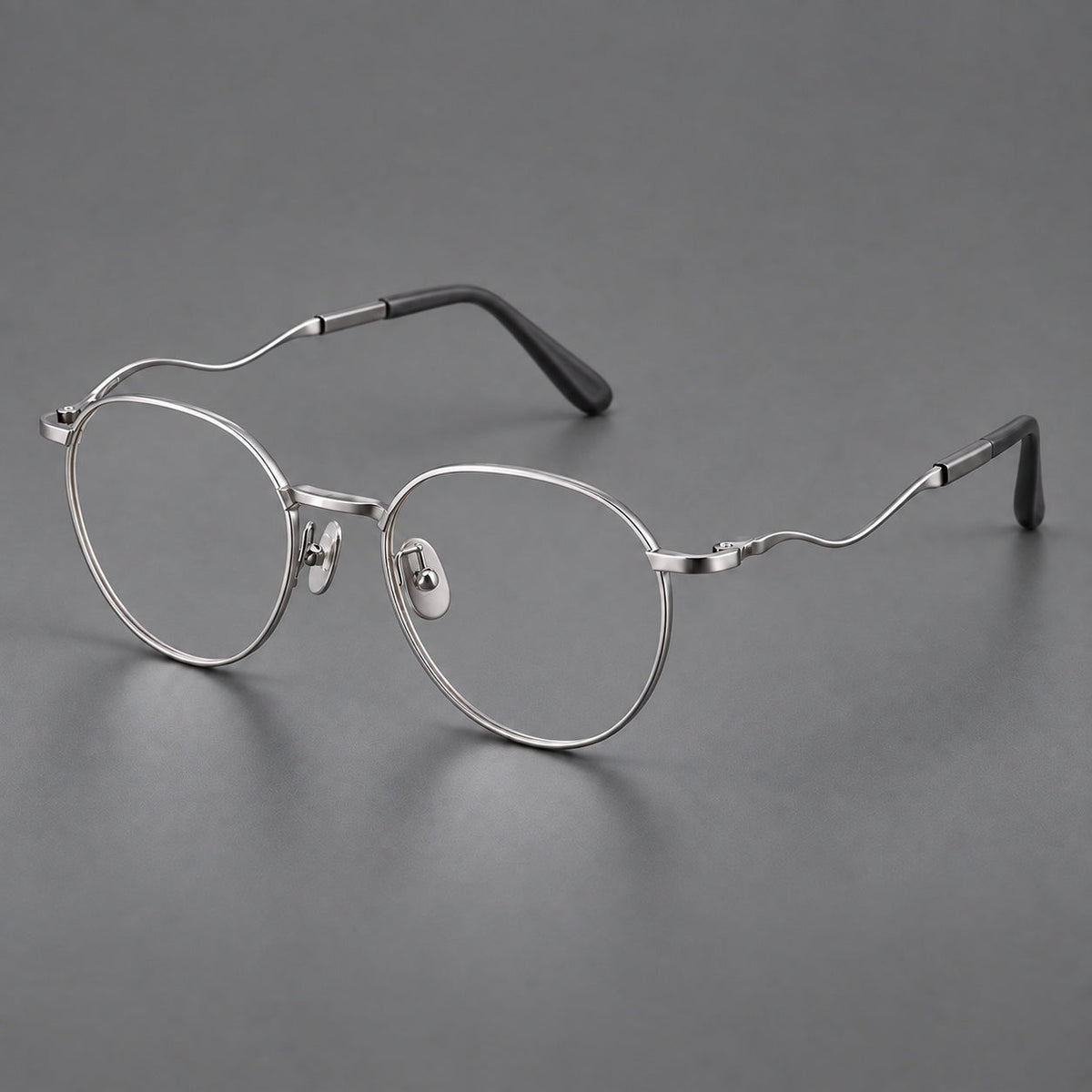 Rounded titanium glasses with a short bridge and distinctive wavy metal temples in Silver, three quarter view