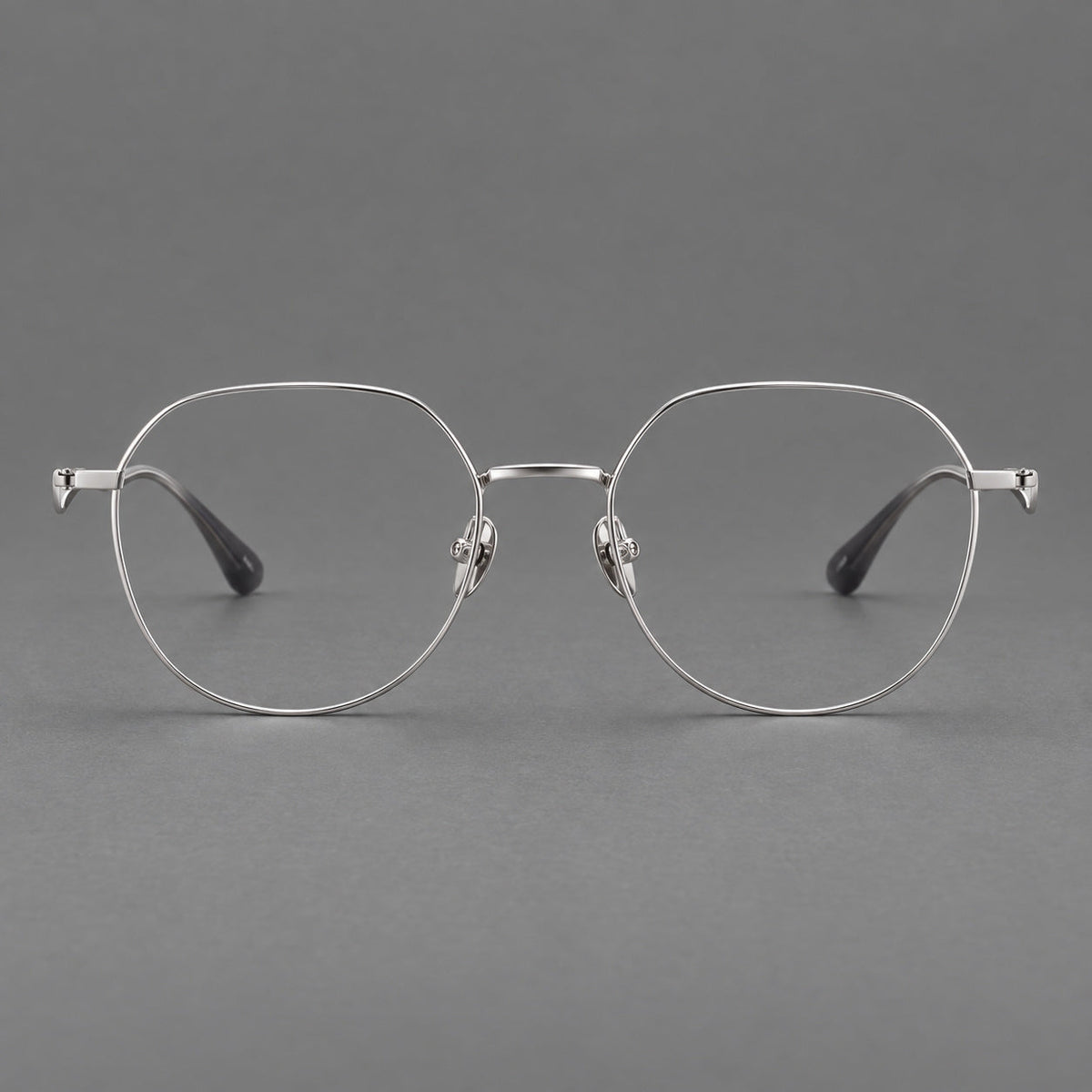 Rounded titanium glasses with a short bridge and distinctive wavy metal temples in Silver, front view