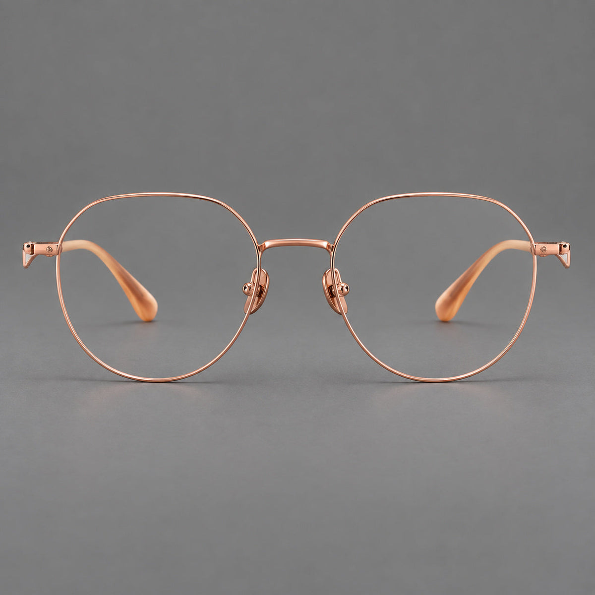 Rounded titanium glasses with a short bridge and distinctive wavy metal temples in Rose Gold, front view