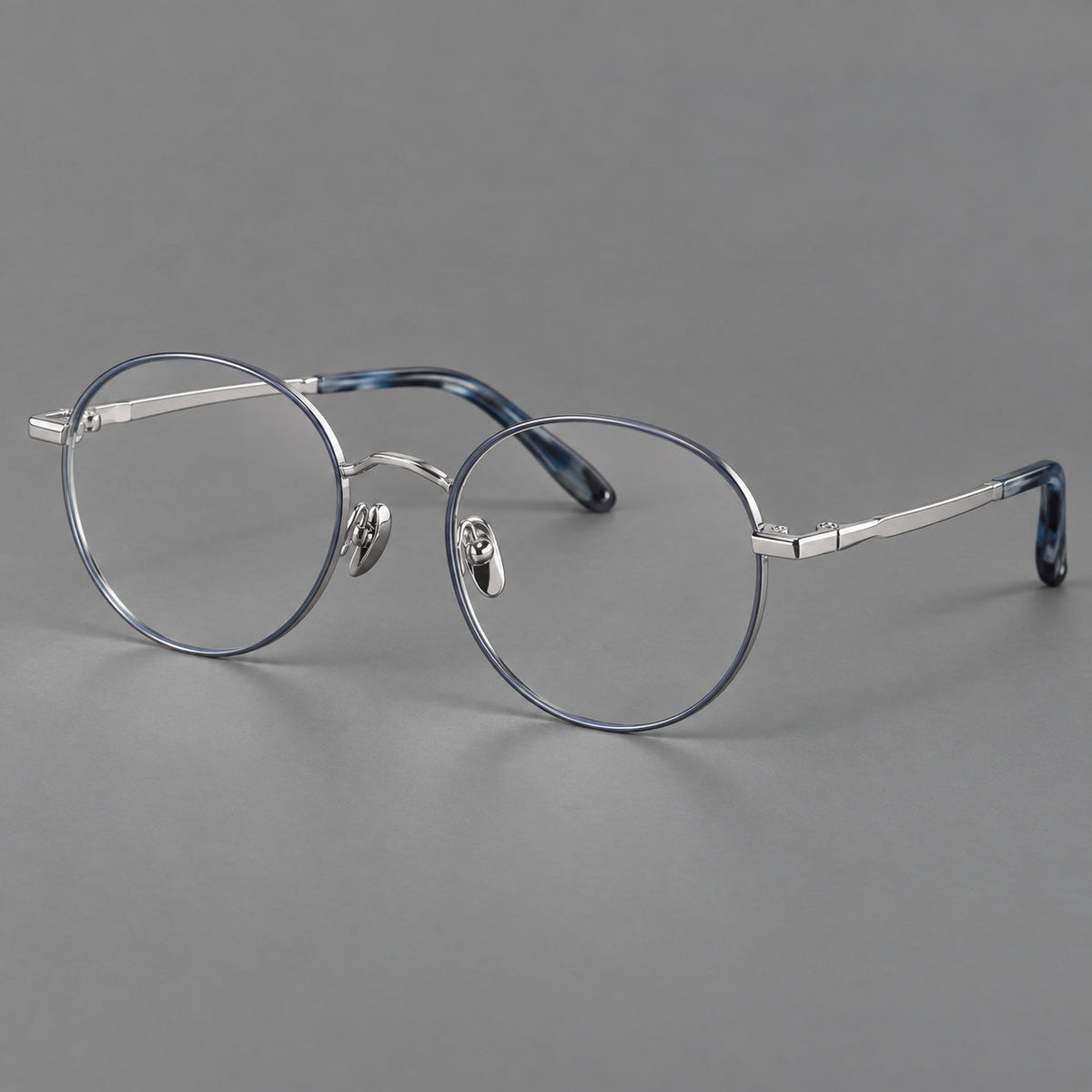 Retro panto titanium glasses with faceted corners and mottled curved temple tips in Gray Blue and Silver, three quarter view