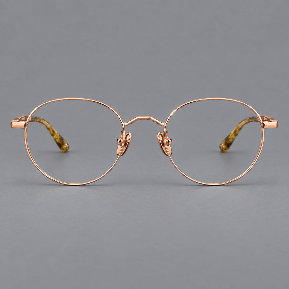 Retro panto titanium glasses with faceted corners and mottled curved temple tips in Rose Gold, front view