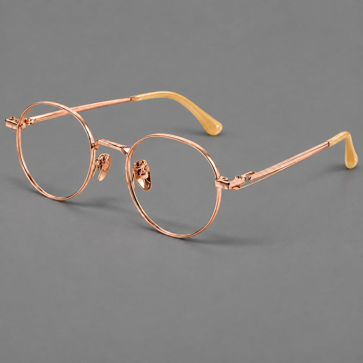 Small panto titanium glasses with an angular bridge and recessed temple details in Rose Gold, three quarter view
