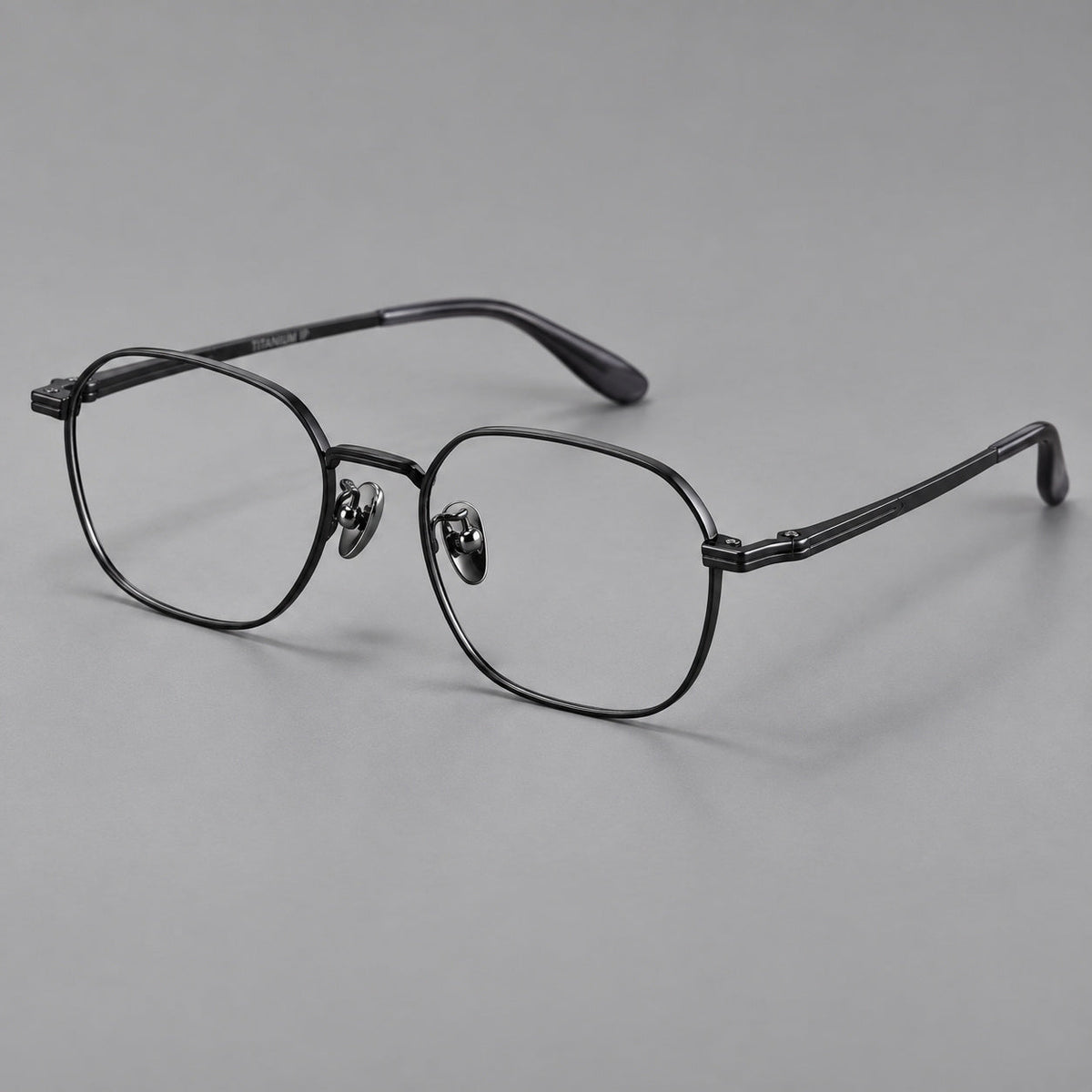 Soft square titanium glasses with an angular bridge and layered corner details in Black, three quarter view