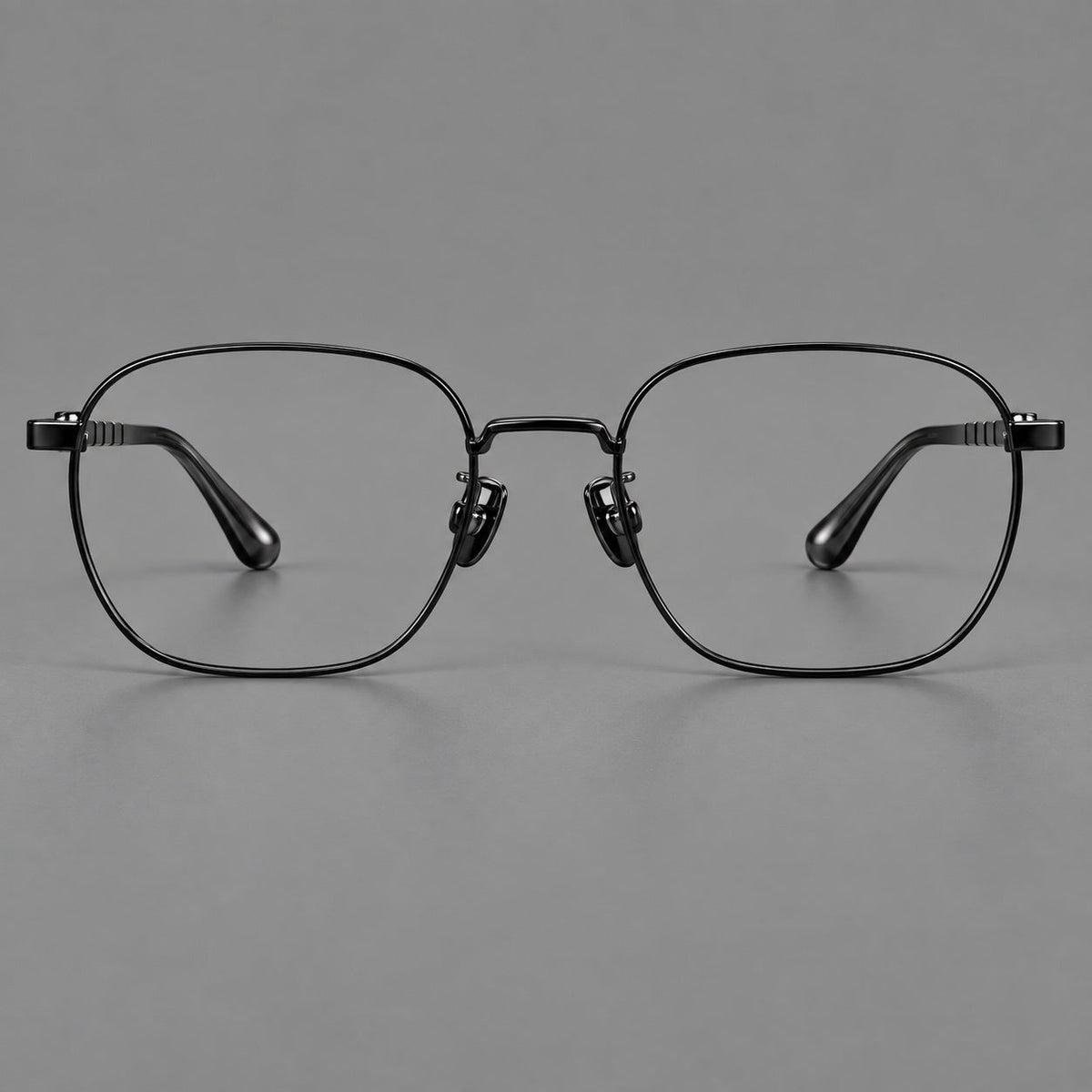 Soft square titanium glasses with a raised bridge and engraved temple bands in Black, front view
