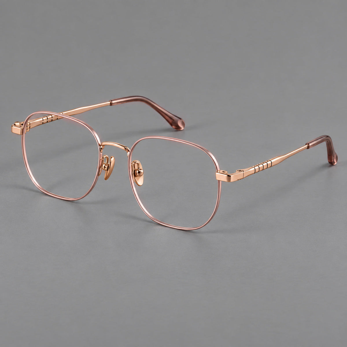 Soft square titanium glasses with a raised bridge and engraved temple bands in Pink and Rose Gold, three quarter view
