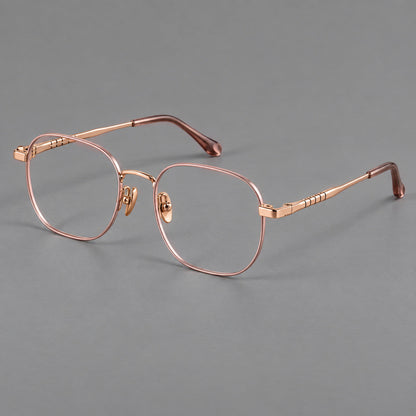 Soft square titanium glasses with a raised bridge and engraved temple bands in Pink and Rose Gold, three quarter view lens detail
