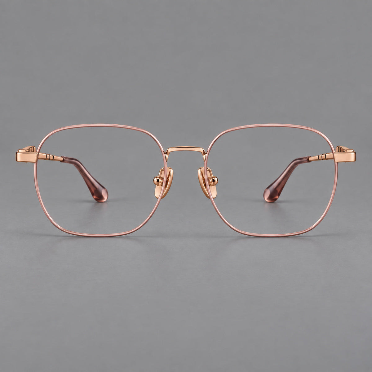 Soft square titanium glasses with a raised bridge and engraved temple bands in Pink and Rose Gold, front view