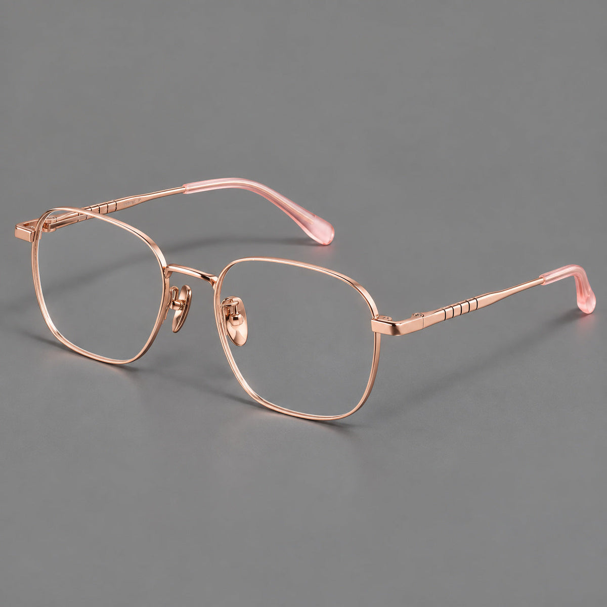 Soft square titanium glasses with a raised bridge and engraved temple bands in Rose Gold, three quarter view