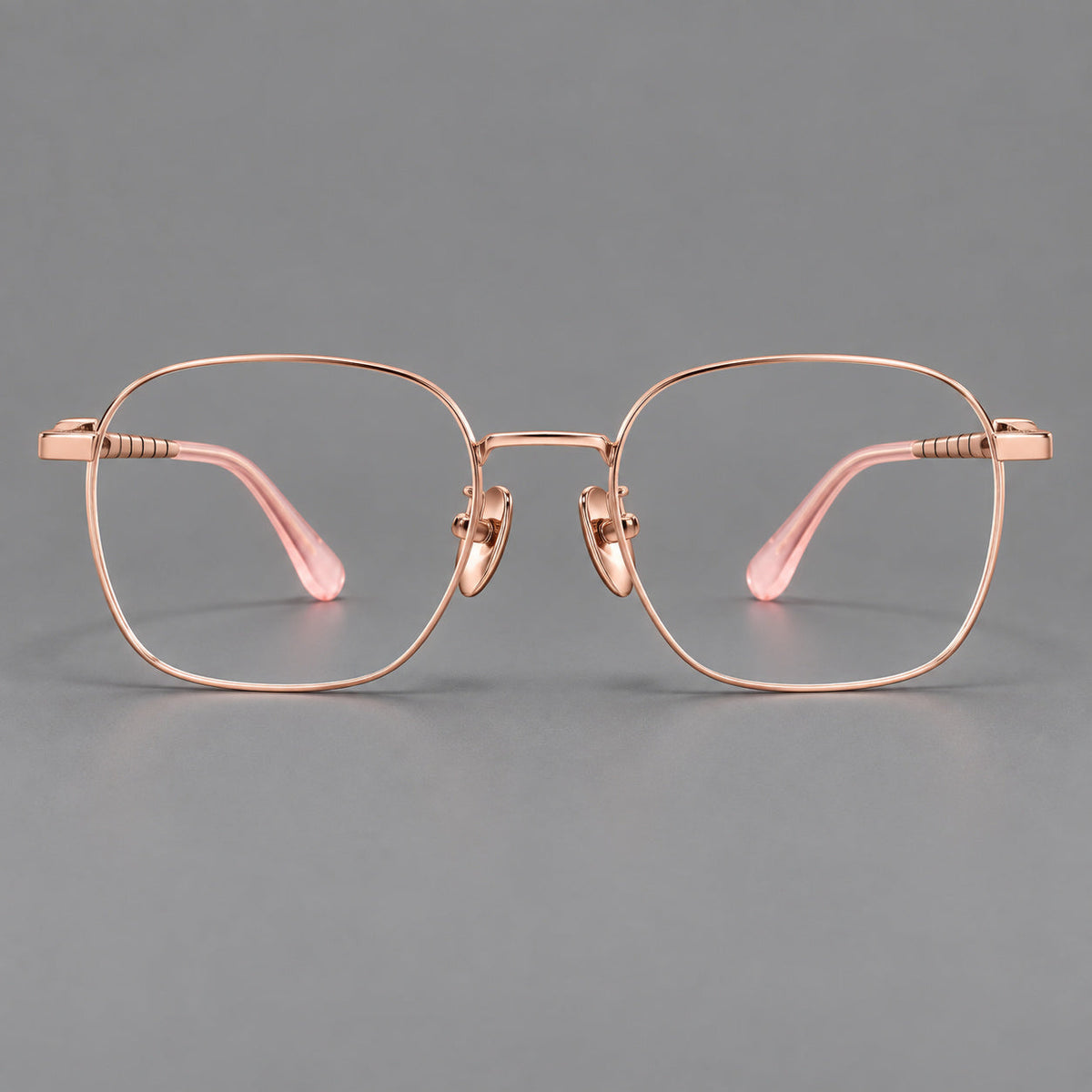 Soft square titanium glasses with a raised bridge and engraved temple bands in Rose Gold, front view