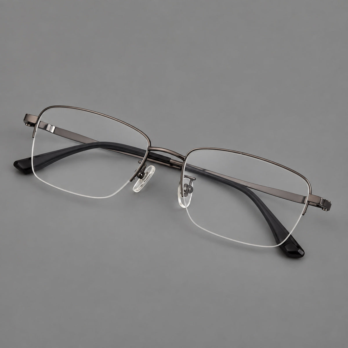 Half frame titanium glasses with rectangular lenses and rounded hinge details in Gunmetal, three quarter view