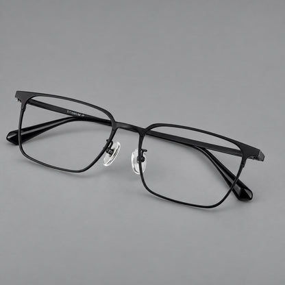Bold rectangular titanium glasses with strong upper corners and flat metal temples in Black, three quarter view