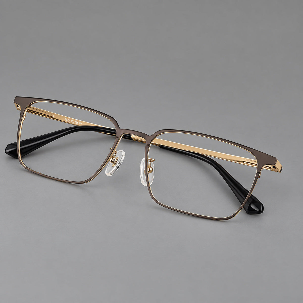 Bold rectangular titanium glasses with strong upper corners and flat metal temples in Gold, three quarter view