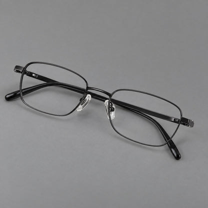 Shallow rectangular titanium glasses with a broad bridge and stepped temple joins in Black, three quarter view