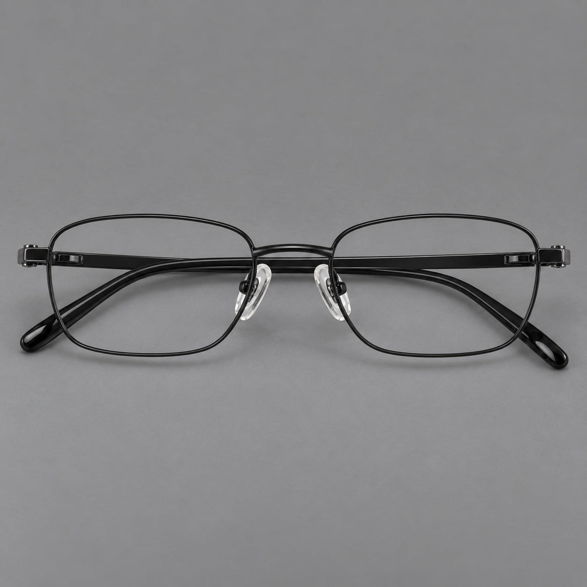 Shallow rectangular titanium glasses with a broad bridge and stepped temple joins in Black, front view