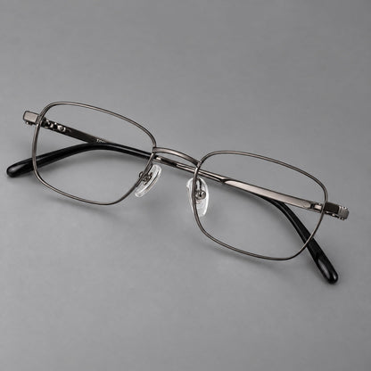 Shallow rectangular titanium glasses with a broad bridge and stepped temple joins in Gunmetal, three quarter view front view