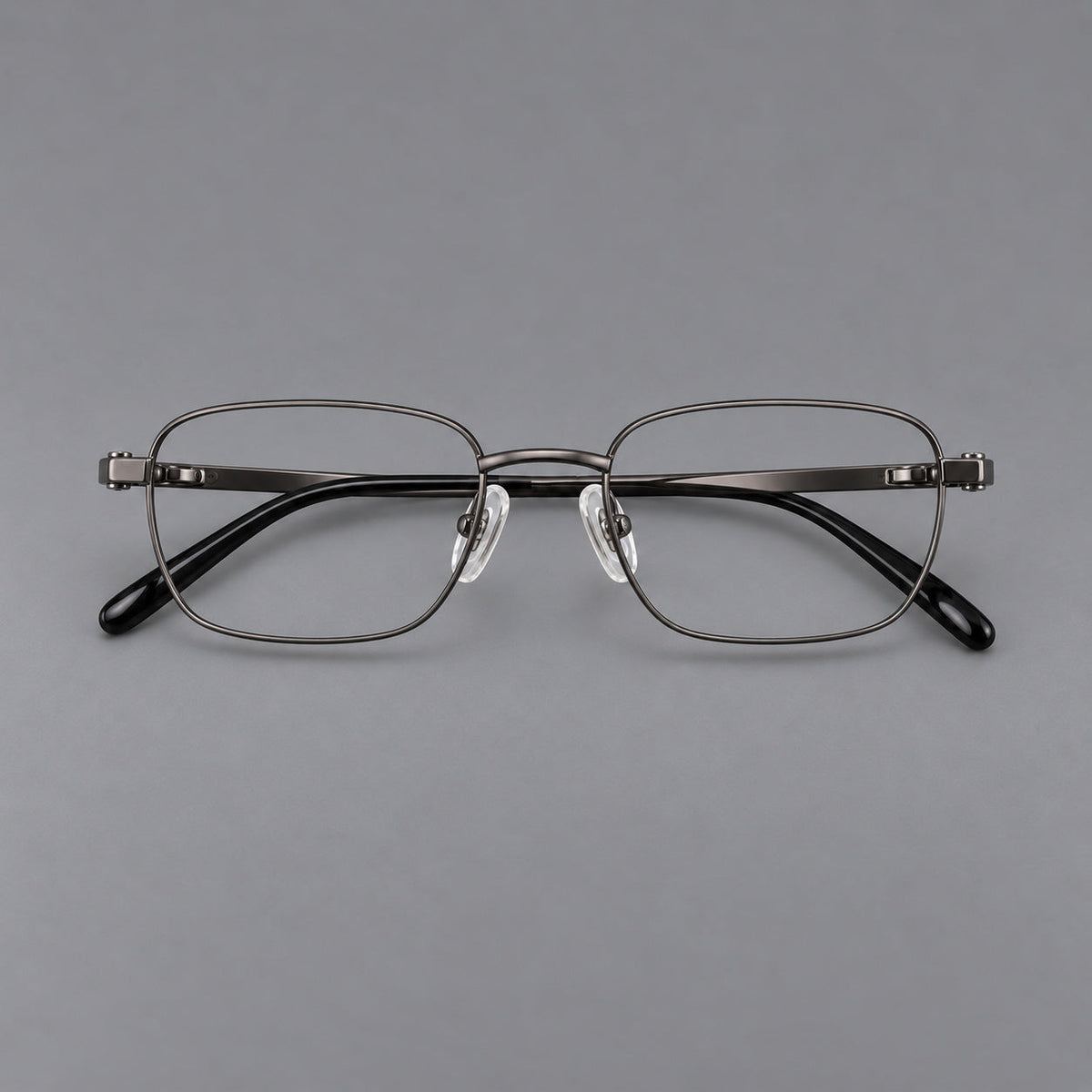 Shallow rectangular titanium glasses with a broad bridge and stepped temple joins in Gunmetal, front view