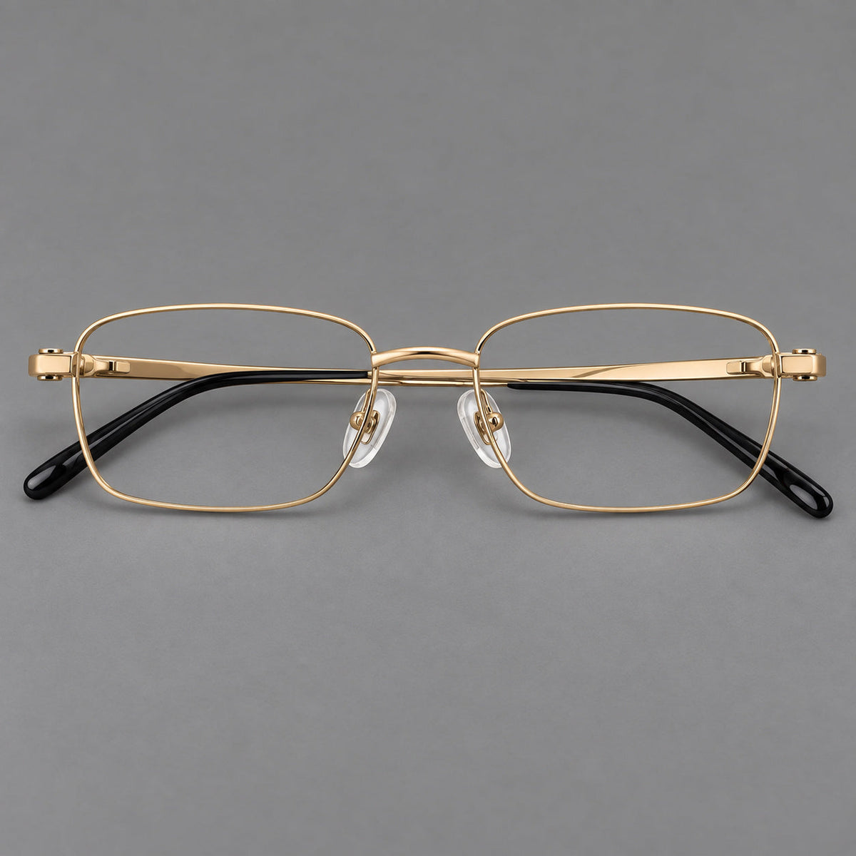 Shallow rectangular titanium glasses with a broad bridge and stepped temple joins in Gold, front view