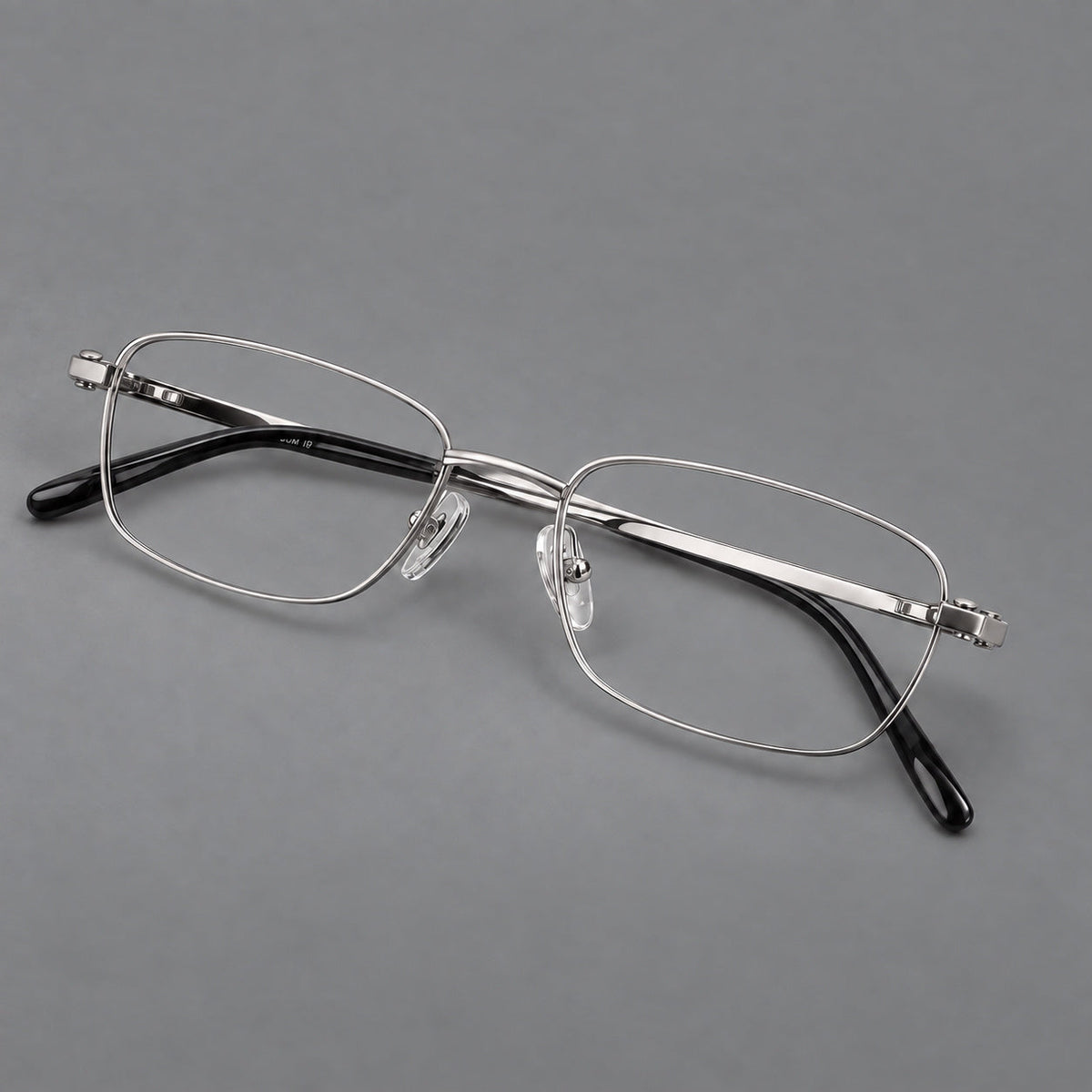 Shallow rectangular titanium glasses with a broad bridge and stepped temple joins in Silver, three quarter view